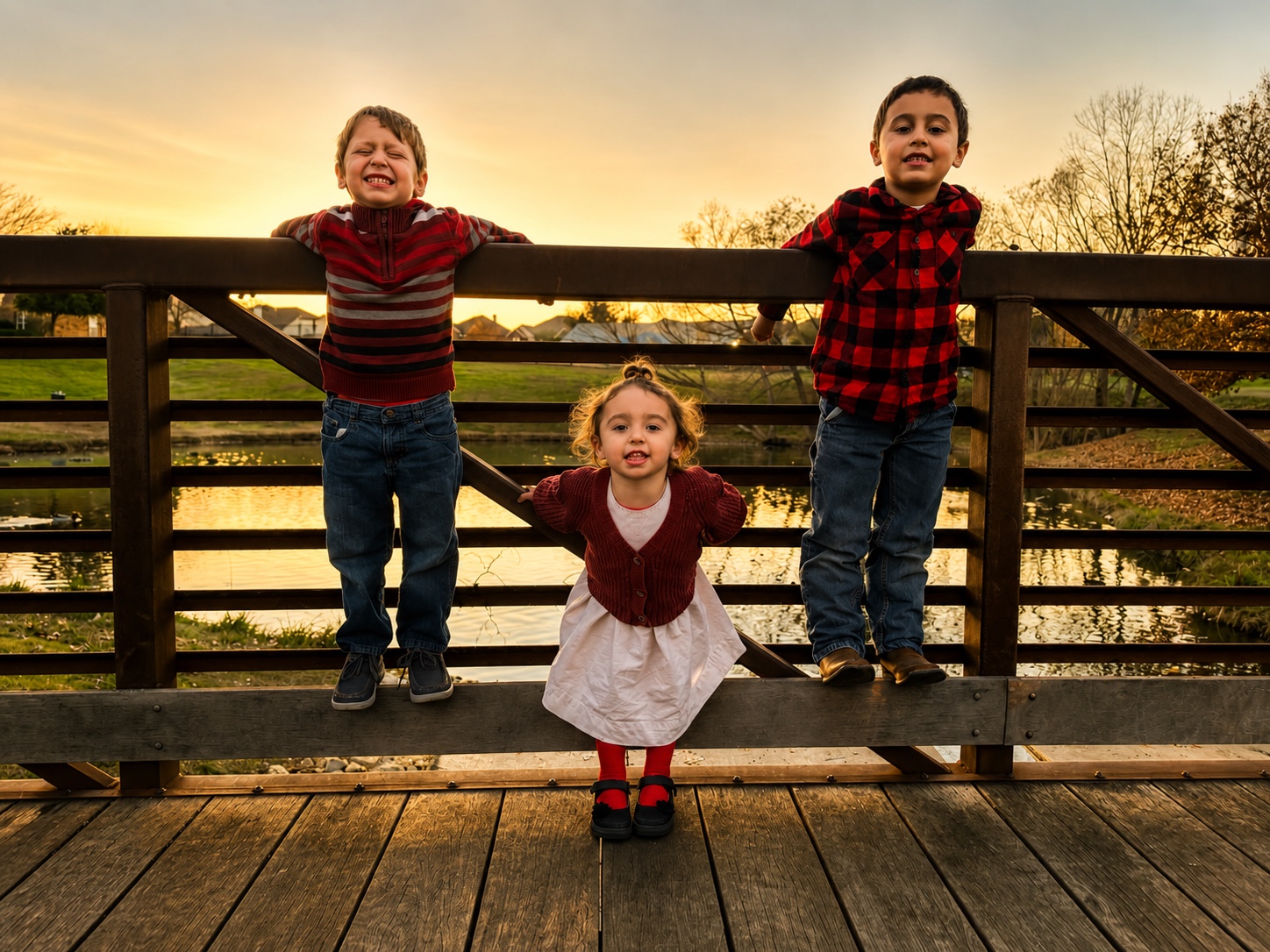 Three children at sunset on a bridge