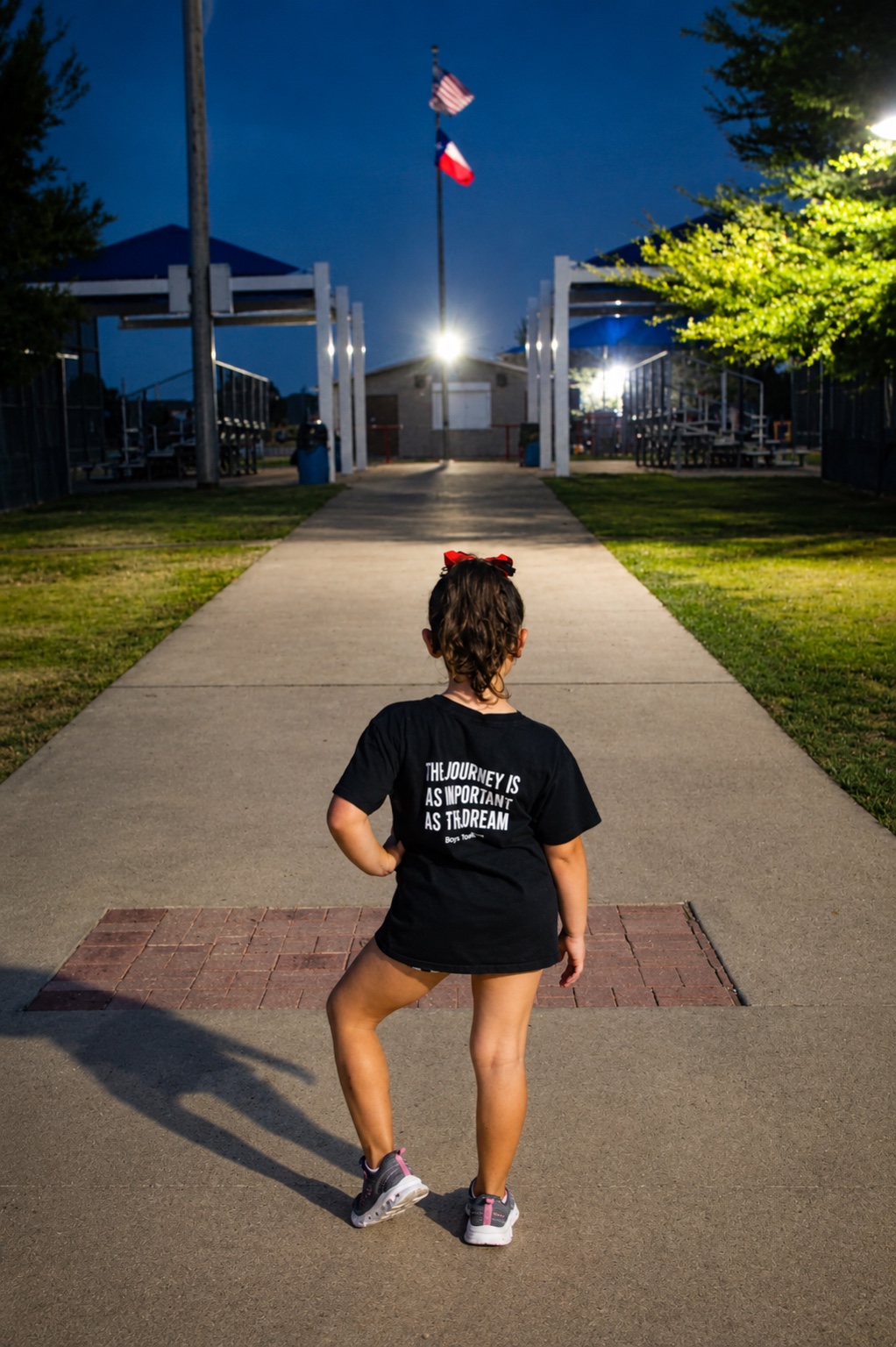 Young athlete walking toward a field at night
